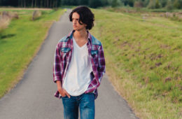 teenage boy walking down road